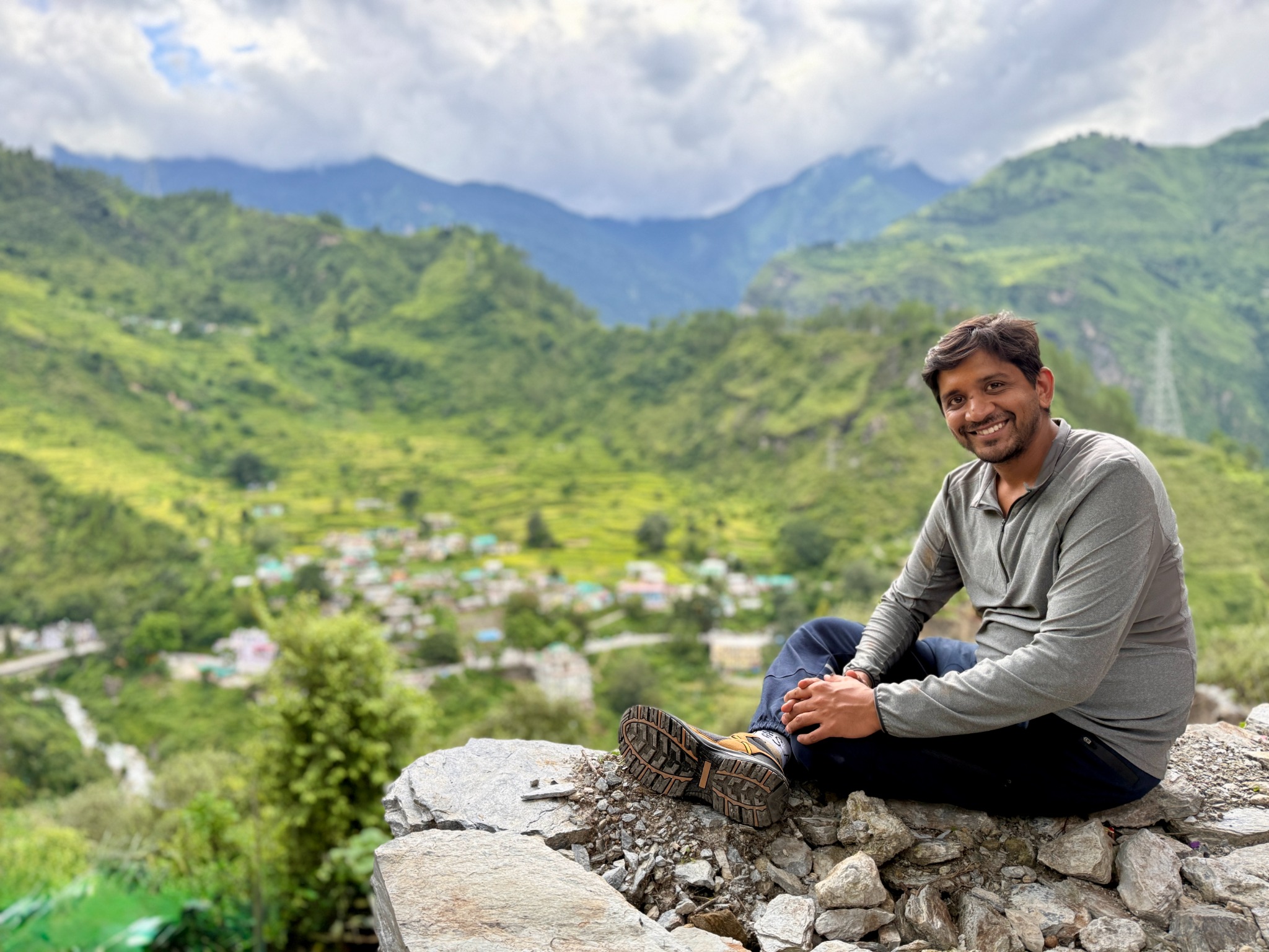 Chetan overlooking a green mountain valley